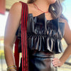Black faux leather romper with wrap front, strapless, and wide ruffle top. 
